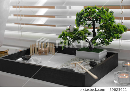 Beautiful miniature zen garden and candles on window sill Beautiful miniature zen garden and candles on window sill 89625621
