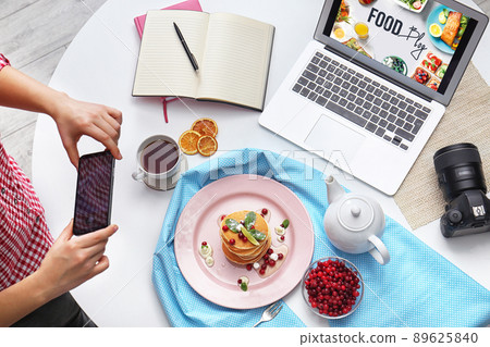 Food blogger taking photo of her breakfast at table, top view 89625840