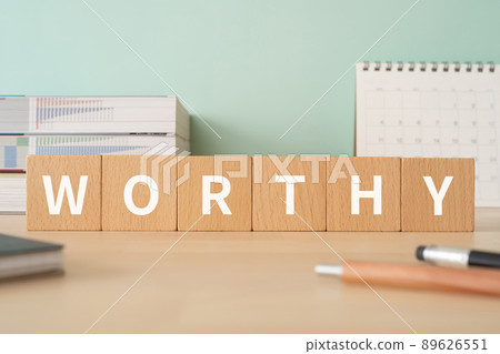Desk with building blocks with "WORTHY" written on it 89626551