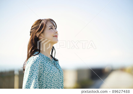 One-piece young woman standing on the beach One-piece young woman standing on the beach 89627488