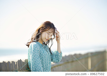 One-piece young woman standing on the beach One-piece young woman standing on the beach 89627502