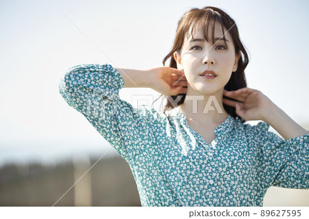 One-piece young woman standing on the beach 89627595