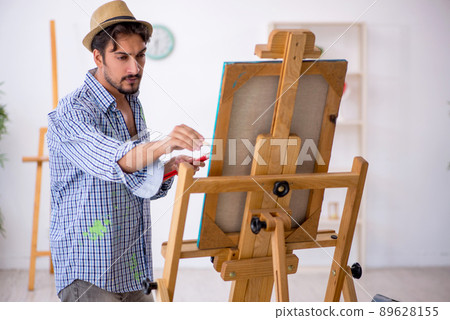 Young man enjoying painting at the studio 89628155