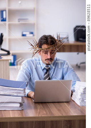Young male employee wearing prickly wreath on head 89628511