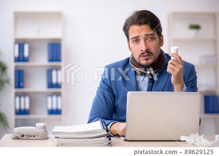 Young male employee suffering at workplace Young male employee suffering at workplace 89629125