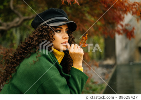 close-up. in profile the face of a girl wistfully looking into the distance who attached to the plump lips finger close-up. in profile the face of a girl wistfully looking into the distance who attached to the plump lips finger 89629427