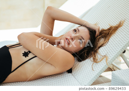 On the shisong lies in a swimsuit girl and touches her hands hair on the head On the shisong lies in a swimsuit girl and touches her hands hair on the head 89629433
