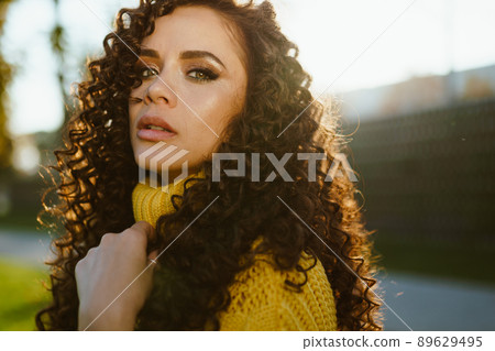 Proudly lifting her chin looks from top to bottom with a menacing look of beauty with chiseled facial features and luxurious hair Proudly lifting her chin looks from top to bottom with a menacing look of beauty with chiseled facial features and luxurious hair 89629495