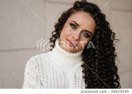 close-up. beautiful girl face with green eyes and full of beautiful lips tilting her head sideways looks with a gentle smile close-up. beautiful girl face with green eyes and full of beautiful lips tilting her head sideways looks with a gentle smile 89629594