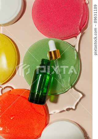 Green glass dropper bottle with white lid in water on bright abstract background. Skincare products , natural cosmetic. Beauty concept for face and body care, brandibg mock up 89631189