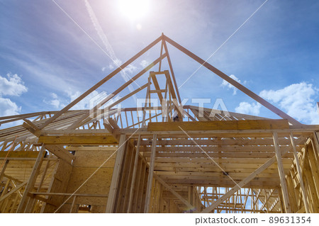 Aerial top view of construction working on the roof beams of under construction wooden built home 89631354