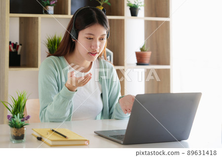 Smiling Asian attentive student studying online class. e-learning education concept. 89631418