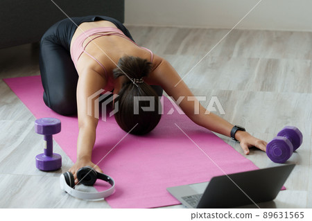 Young woman practicing yoga follow teacher in laptop online class at home. Calmness and relax concept. Young woman practicing yoga follow teacher in laptop online class at home. Calmness and relax concept. 89631565