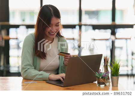 Woman using online payment and holding credit card. Online Shopping concept. Woman using online payment and holding credit card. Online Shopping concept. 89631702