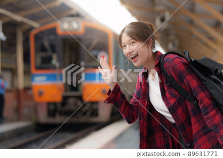 Pretty Young traveler woman excite and planning trip at train station. Summer and travel lifestyle concept. Pretty Young traveler woman excite and planning trip at train station. Summer and travel lifestyle concept. 89631771