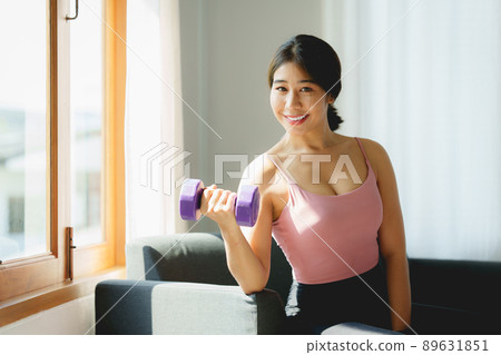 Beautiful woman exercising with dumbbells at home. bodybuilding, fitness, sport, weightlifting concept. Beautiful woman exercising with dumbbells at home. bodybuilding, fitness, sport, weightlifting concept. 89631851
