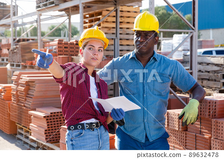 Man and woman talking in construction material storage Man and woman talking in construction material storage 89632478