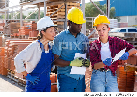 Builders and taskmaster having conversation in warehouse Builders and taskmaster having conversation in warehouse 89632480