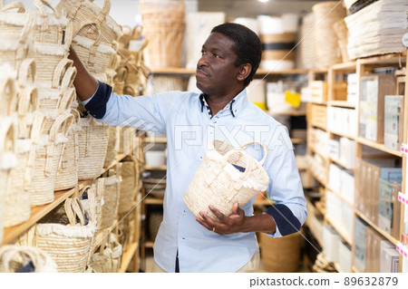 Man choosing wicker basket at hardware store 89632879