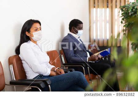 Hispanic woman in protective mask waiting for job interview in office 89632882