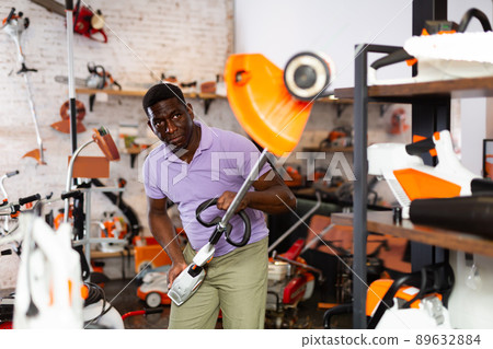 Man selecting new strimmer in gardening tools shop 89632884