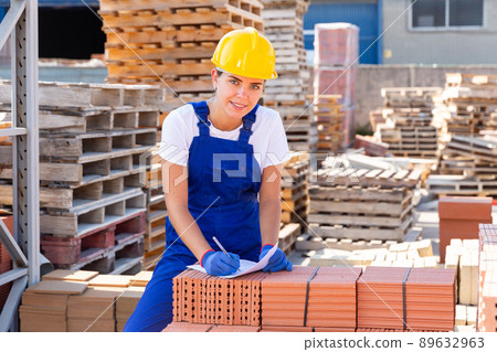 Girl worker keeps records of ceramic tiles Girl worker keeps records of ceramic tiles 89632963