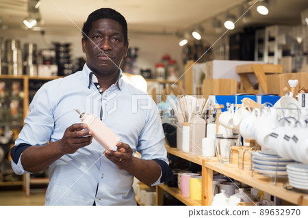 Portrait of man choosing deodorant in dishware store 89632970
