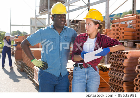 Two storekeepers with an estimate in their hands discuss working issues in the warehouse Two storekeepers with an estimate in their hands discuss working issues in the warehouse 89632981