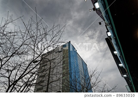 Sky and skyscrapers looking up from the illuminated store entrance 89633010