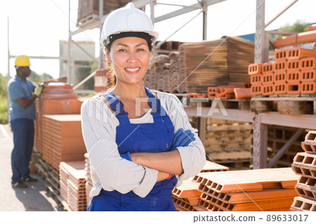 Asian woman worker posing at hardware store Asian woman worker posing at hardware store 89633017