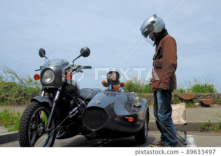 A driver relaxing with a teddy bear in a parking lot near the coast 89633497