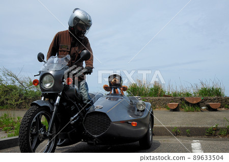 A driver relaxing with a teddy bear in a parking lot near the coast 89633504