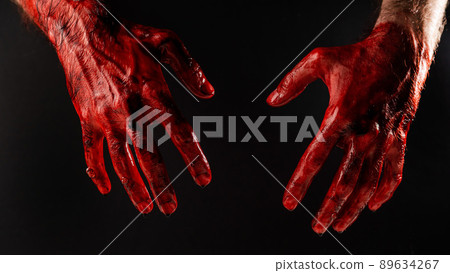 Male bloody hands on a black background.  89634267