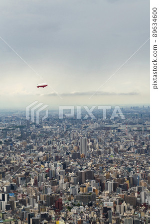 一艘飛艇漂浮在一座大城市的天空中 一艘飛艇漂浮在一座大城市的天空中 89634600