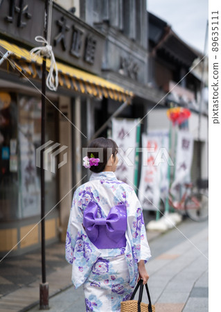 Back view of a woman walking in a yukata on Taisho Roman Yume-dori in Koedo Kawagoe 89635111