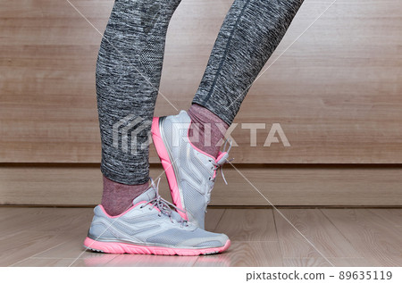 Fit female leg in sport shoe stand 89635119