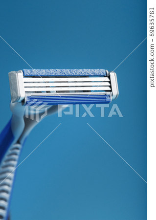Shaving machine with three blades on a blue background close-up free space 89635781
