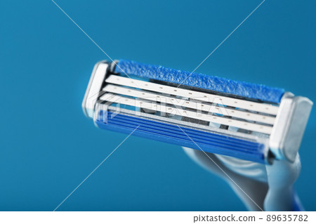 Shaving machine with three blades on a blue background close-up free space Shaving machine with three blades on a blue background close-up free space 89635782