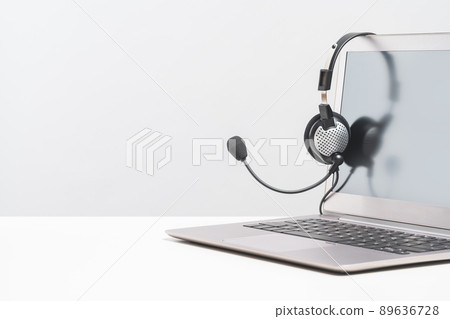 Laptop with headphones on white desk banner 89636728