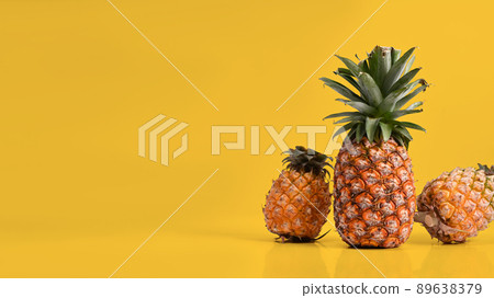 Three ripe pineapples against yellow background. Summer vacation beach, copy space. Three ripe pineapples against yellow background. Summer vacation beach, copy space. 89638379