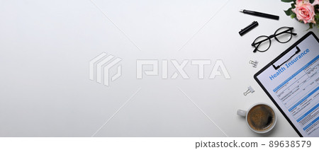 Health insurance form, glasses and coffee cup on white background with copy space. Health insurance form, glasses and coffee cup on white background with copy space. 89638579