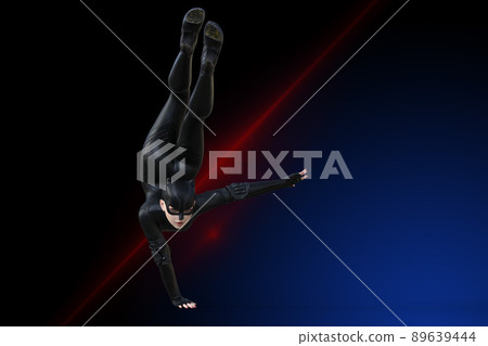 一個穿著黑色貓形象西裝的超級英雄女人，一隻手倒立著 89639444