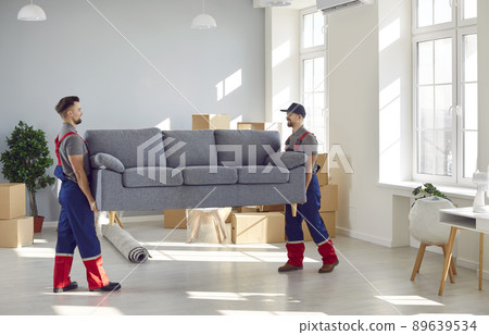 Male loaders take sofa out of apartment while fulfilling order at moving service. 89639534