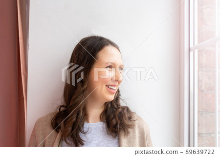 Portrait caucasian youn woman by the window. Portrait caucasian youn woman by the window. 89639722