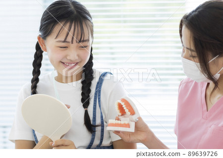 Girl receiving tooth brushing instruction in dentistry 89639726