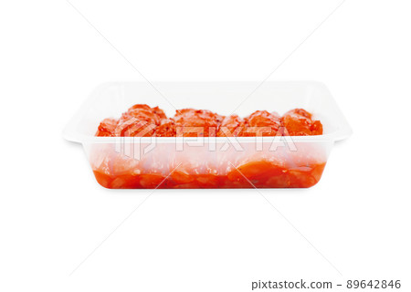 Marinated chicken fillet in red sauce in a transparent tray on an isolated background. Side view. Copy space.Fast food, food at home. 89642846