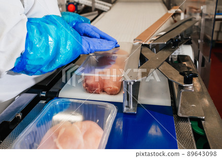 Line for the production of semi-finished meat products.Meat processing in food industry.Packing of meat slices in boxes on a conveyor belt.modern poultry processing plant. 89643098