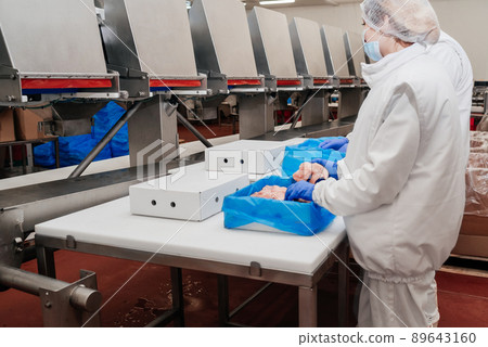 Line for the production of semi-finished meat products.Meat processing in food industry.Packing of meat slices in boxes on a conveyor belt.modern poultry processing plant. 89643160