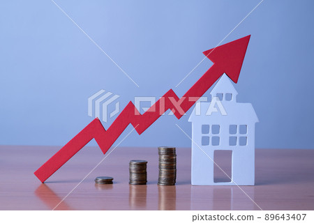 Coins on a table, a red up arrow and house. The concept of the rising price of real estate 89643407