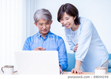 Adult parents and children using laptops in the living room Adult parents and children using laptops in the living room 89644249